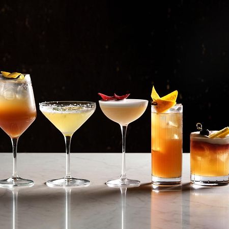 Middle Eight - Covent Garden - Preferred Hotels And Resorts London Exterior photo The photo features a selection of five different cocktails lined up on a marble surface. Each drink is served in a distinct glass, showcasing a variety of colors and garnishes. 

1. The first cocktail is in a large wine glass, with a gradient color f