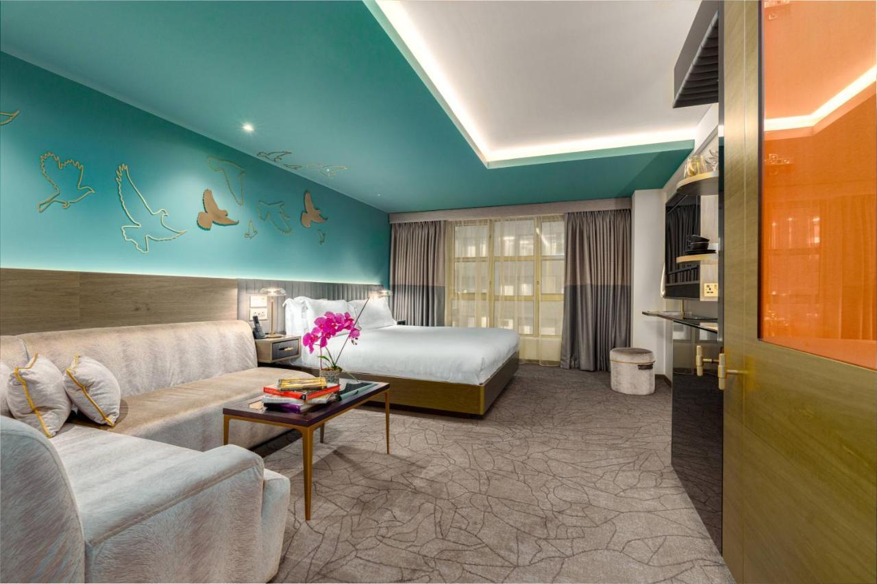 Middle Eight - Covent Garden - Preferred Hotels And Resorts London Exterior photo The photo shows a modern hotel room featuring a blend of comfort and style. The room has a light-colored floor with a textured design, and the walls are adorned with a vibrant turquoise accent wall that features decorative butterfly motifs. 

There i