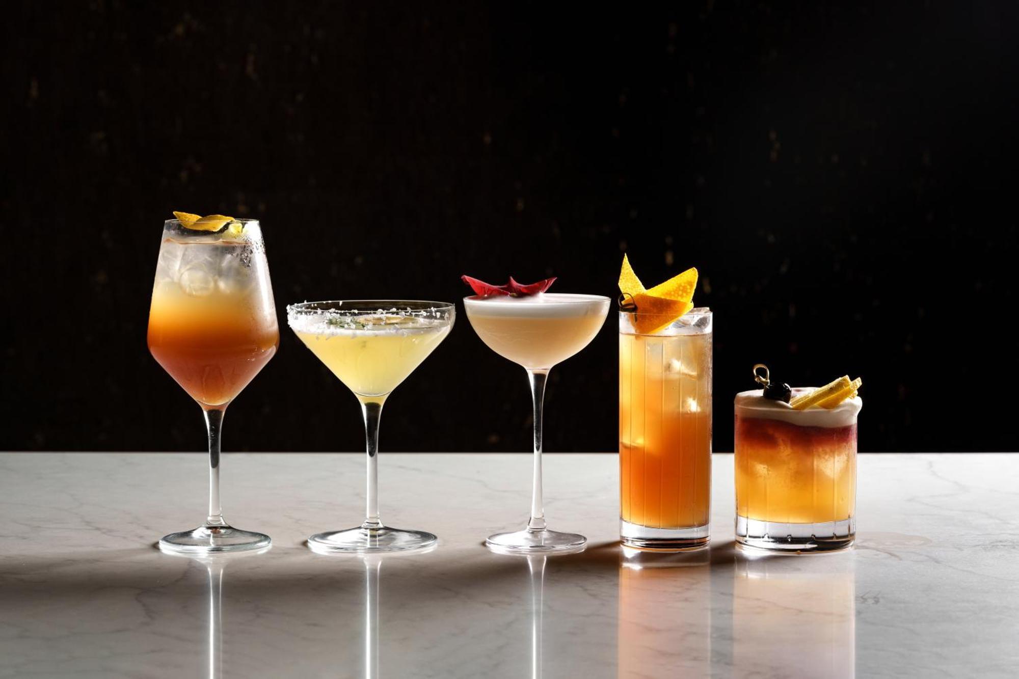 Middle Eight - Covent Garden - Preferred Hotels And Resorts London Exterior photo The photo features a selection of five different cocktails lined up on a marble surface. Each drink is served in a distinct glass, showcasing a variety of colors and garnishes. 

1. The first cocktail is in a large wine glass, with a gradient color f