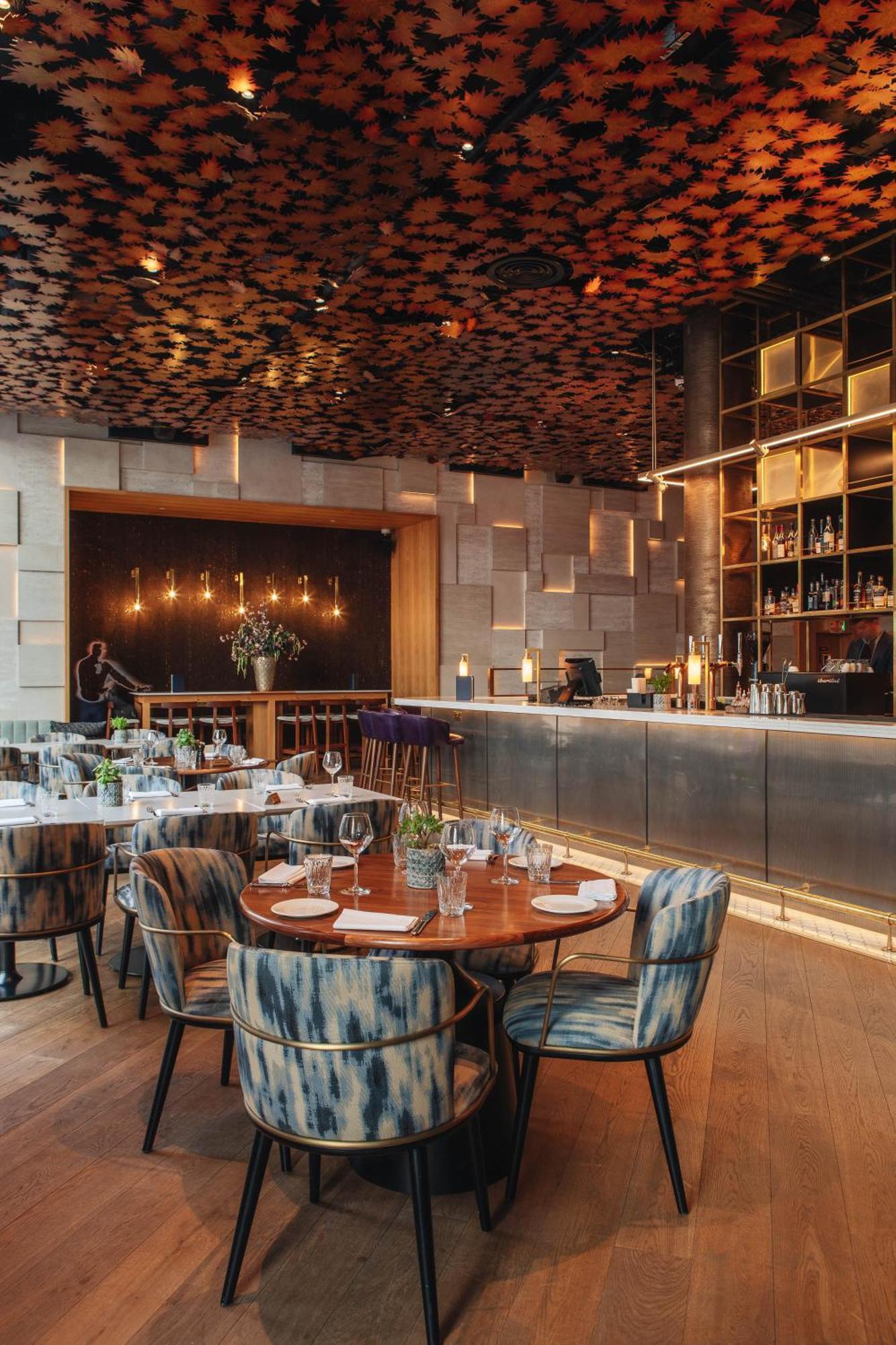 Middle Eight - Covent Garden - Preferred Hotels And Resorts London Exterior photo The photo shows a stylish restaurant interior. There are round tables set with plates and glasses, surrounded by comfortable chairs. The bar area is sleek and modern, with a counter displaying various bottles. The lighting appears warm and inviting, 